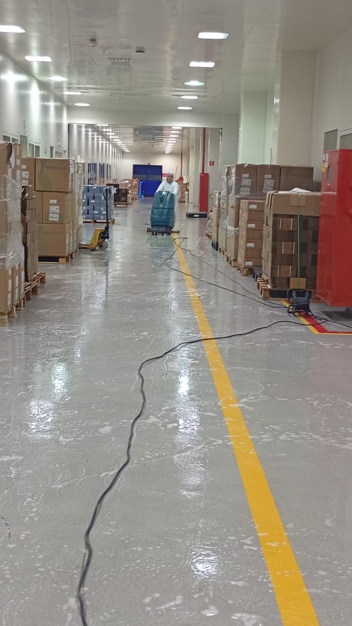 Equipe J.S.A realizando limpeza mecanizada em corredor industrial